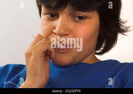 Boy biting his finger nails, dreaming Stock Photo