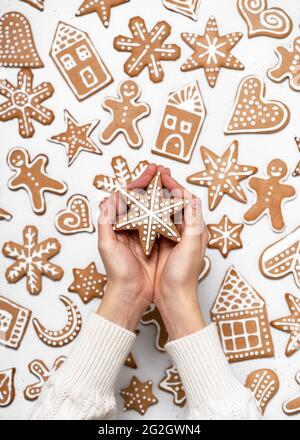 Child hands holding a homemade Christmas painted gingerbread in the form of a star. Scandinavian pattern. Top view. Stock Photo