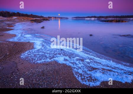 Beautiful winter evening with moonrise and earth shadow, at Oven in Råde, by the Oslofjord, Østfold, Norway. Stock Photo