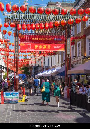 People out and about and dining al fresco. Wardour Street in London's Chinatown area. London, England, UK Stock Photo