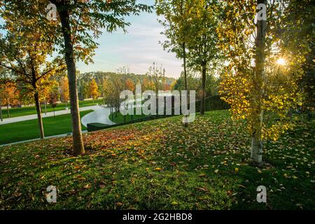 Amazing autumn in park Galitskogo in Krasnodar - orange leaves on green grass. Good sunny day oin south of Russia. Stock Photo