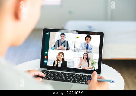 Business people use laptops for web meetings at home, discuss work and schedules with colleagues through webcams Stock Photo