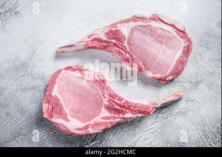 Raw dry aged tomahawk pork chop steak. White background. Top view Stock Photo