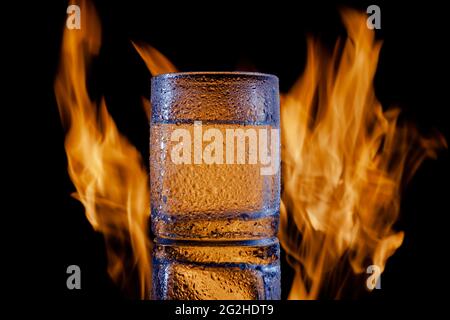 glass of tequila in drops of water on a black background Stock Photo