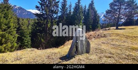 The memorial stone stands without lettering with a simple metal cross on the edge of the forest. The cause and reason are not known Stock Photo