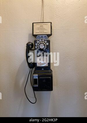 rotary pay phone on a wall Stock Photo