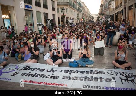 Malaga, Spain. 12th June, 2021. Protesters sitting on the ground at Marques de Larios street as they take a moment of silence in memory of the two girls, during the demonstration. Hundreds of people take the streets against violence on women and gender-based violence after bodies of two girls murderer by the father, Tomas Gimeno were found at the sea from Canary Islands. The crime has shocked the country causing several protests and tributes in memory of the girls. Credit: SOPA Images Limited/Alamy Live News Stock Photo