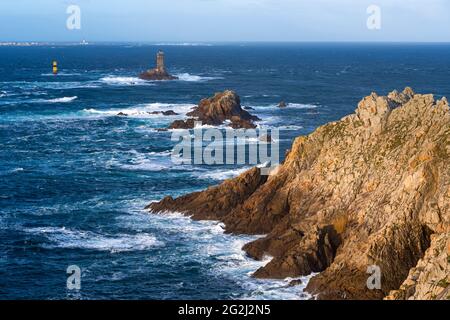 Rocky coast of the Pointe du Raz, lighthouse La Vieille in the sea, in the background the Île de Sein, France, Brittany, Finistère department Stock Photo