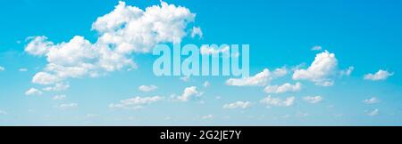 amazing cloud formations on a bright blue sky. beautiful side lit cloudscape panorama in springtime. many white clouds in summer blue sky. Cloudscape Stock Photo