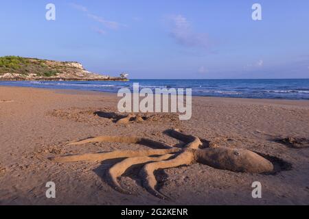 Octopus sand sculpture: beach art.The most beautiful beaches of Apulia in Italy: Gusmay beach in Gargano promontory near town of Peschisci, Stock Photo