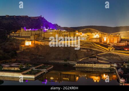 Amer fort illuminated at night one of principal attractions in Jaipur, Rajastan, India refelcting in Maota lake in twilight. Stock Photo