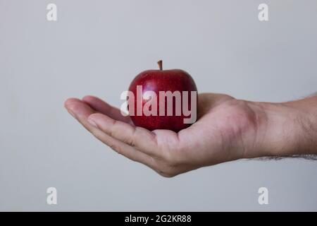 Man holding a apple in hand white isolated background. Stock Photo