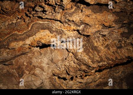 The Twisted Mineral Seams in an Underground Cavern. Stock Photo