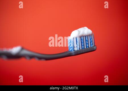 toothbrush with toothpaste on a red background. Stock Photo