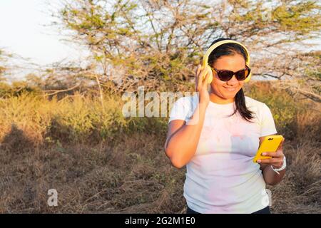 Smiling middle-aged woman using cell phone in the field Stock Photo