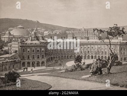 A late 19th century view of Buxton Crescent in the town of Buxton, Derbyshire, England from the Slopes, a steep landscaped hillside where warm spring water at a constant 27.5 °C (81.5 °F), has flowed for thousands of years from St Ann's Well. The crescent owing much to the Royal Crescent in Bath, was designed by the architect John Carr of York, and built for the 5th Duke of Devonshire between 1780 and 1789. Stock Photo