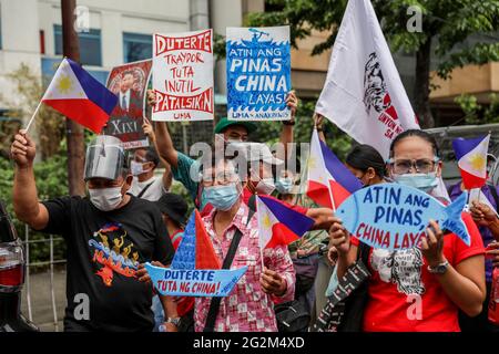 Metro Manila, Philippines. 12th June 2021. Activists shout slogans during a protest in front of the Chinese consulate marking Independence Day in the financial district of Makati. Various groups called on China to stop its maritime activities in the disputed South China Sea, which endangers peace and stability in the region. Credit: Majority World CIC/Alamy Live News Stock Photo