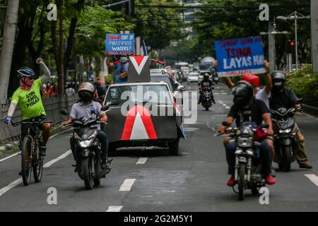 Metro Manila, Philippines. 12th June 2021. Activists carry signs as they hold a motorcade in front of the Chinese Consulate in the financial district of Makati. Various groups called on China to stop its maritime activities in the disputed South China Sea, which endangers peace and stability in the region. Credit: Majority World CIC/Alamy Live News Stock Photo