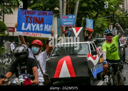 Metro Manila, Philippines. 12th June 2021. Activists carry signs as they hold a motorcade in front of the Chinese Consulate in the financial district of Makati. Various groups called on China to stop its maritime activities in the disputed South China Sea, which endangers peace and stability in the region. Credit: Majority World CIC/Alamy Live News Stock Photo