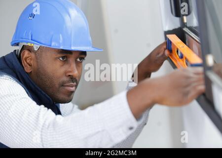 handyman installing window sill using leveler and laser leveler Stock Photo
