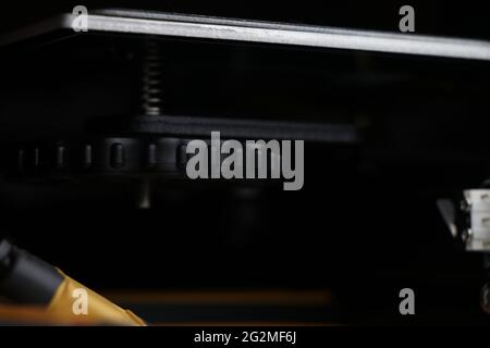 Leveling bed screws of three dimensional printer. 3D Printer heating bed height level adjustment screw close-up Stock Photo