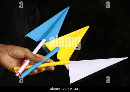 Group of paper airplanes held in hand. Origami paper aircraft Stock Photo
