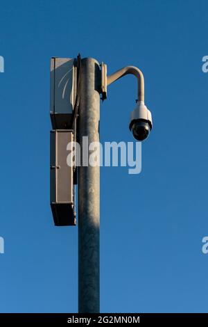360 Degree CCTV security camera fixed on a pole on a blue sky background - security, big brother concept - portrait orientation Stock Photo