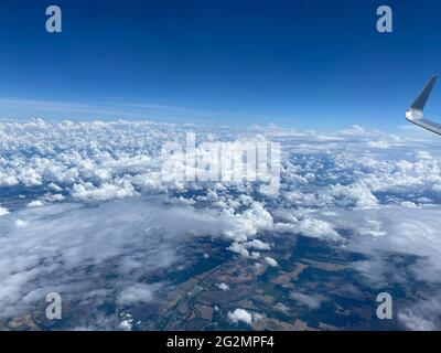View from the airplane window flying above the clouds. Stock Photo