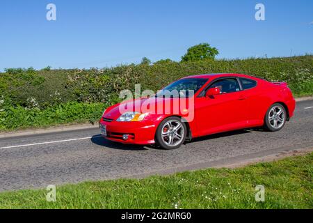 2004, red Hyundai Coupe Se 1975cc petrol coupe, en-route to Capesthorne Hall classic May car show, Cheshire, UK Stock Photo