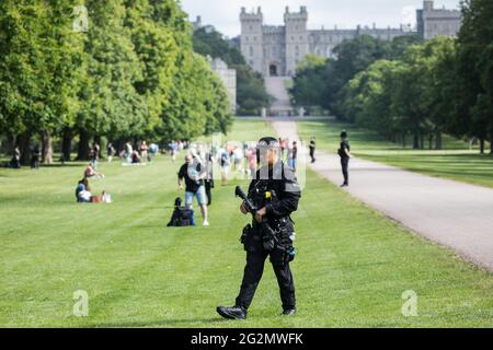 Windsor, UK. 12th June, 2021. An authorised firearms officer (AFO) from Thames Valley Police patrols the Long Walk in Windsor Great Park prior to the ceremony of Trooping the Colour at Windsor Castle to mark the Queen's official birthday. A socially distanced and scaled down Trooping the Colour ceremony is taking place this year incorporating many of the elements from the annual ceremonial parade on Horse Guards, with F Company Scots Guards Trooping the Colour of the 2nd Battalion Scots Guards in the Castle Quadrangle. Credit: Mark Kerrison/Alamy Live News Stock Photo