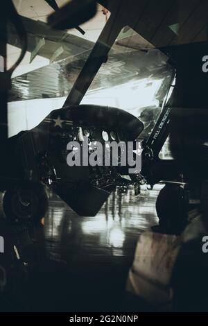 Duxford England May 2021 Vertical shot of the interior cockpit of the Huey helicopter, famous after the vietnam war. Dark glossy reflections of the ca Stock Photo