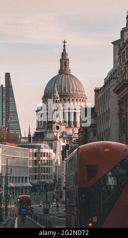 Famous London City Cathedral, St Pauls, with the well-known red London buses along the street ending in the magnificent building Stock Photo