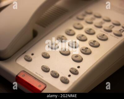 close up soft focus on telephone devices at hotel desk with yellow light effect, communication technology concept Stock Photo