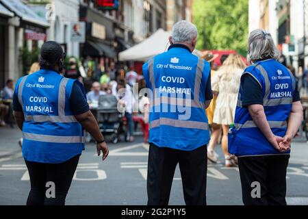 London, UK. 12 June 2021.  City of Westminster Covid Marshals on patrol in Soho.  Scientific advisers to the UK government have called for a delay to the complete lifting of coronavirus lockdown restrictions on 21 June, possibly by four weeks, to allow scientists to assess the link between rising numbers of Covid-19 cases (mainly the newly identified Delta variant) and hospital admissions.  Credit: Stephen Chung / Alamy Live News Stock Photo
