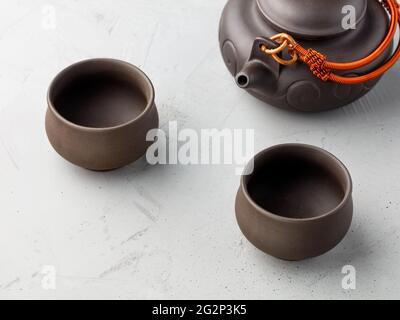 Antique tea earthenware set in a set of two brown cups with a teapot on a gray concrete background. Copy space. Stock Photo