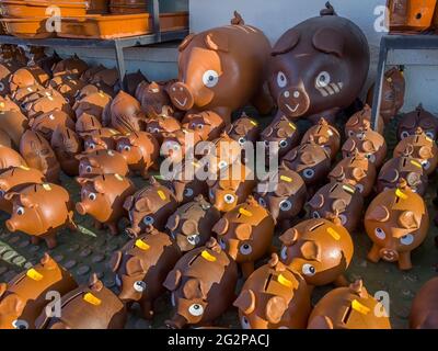 street stall with a herd of ceramic pigs, piggy banks in various sizes in a street market, stand selling handicraft piggy banks Stock Photo