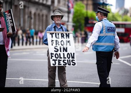 A police officer holds a pro-Palestine campaigner during a protest ...