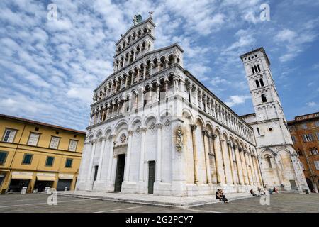 Lucca, Italy - May 23, 2021: Church and square of San Michele (Saint Michael) in Lucca, Tuscany (Italy). View of the white marble building over blue c Stock Photo