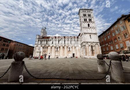Lucca, Italy - May 23, 2021: Church and square of San Michele (Saint Michael) in Lucca, Tuscany (Italy). View of the white marble building over blue c Stock Photo