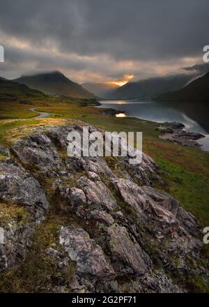 Dramatic morning light breaking through dark stormy clouds at Wastwater in the Lake District, UK. Stock Photo