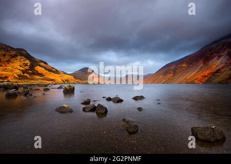 Storm clouds and beautiful sunset light on mountains at Englands deepest lake Wastwater in the Lake District, UK. Stock Photo