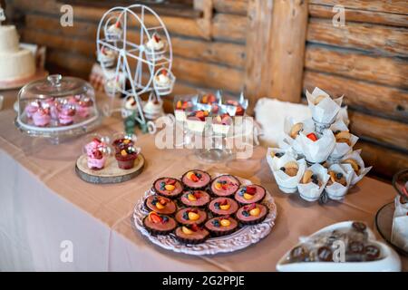 Mini cakes, biscuits and sweets displayed on table, closeup shallow depth of field photo Stock Photo