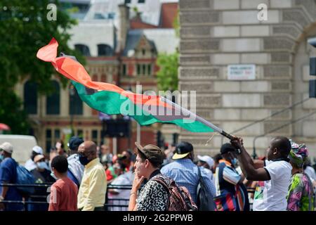 London  UK - 12 June 2021 - Protester waving Biafran large flag at Biafra protest on corner of whitehall and westminster square in Central london whi Stock Photo