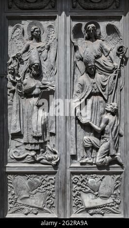 Close-up of the bronze entrance door of the Church of Our Lady of Consolation with sculptures representing St Augustine and St Thomas, Genoa, Italy Stock Photo