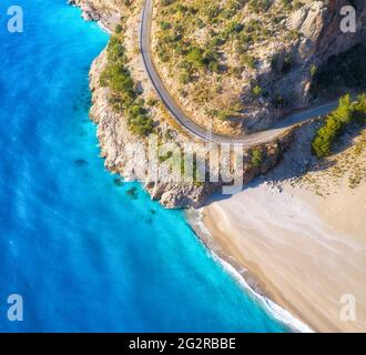 Aerial view of mountain road near blue sea with sandy beach Stock Photo