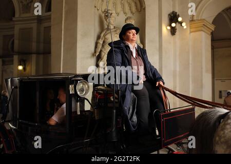 Like film frame, Those who tour the old town by horse-drawn carriage, in the Hofburg palace passage corridor Stock Photo