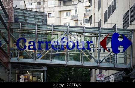 Bucharest, Romania - June 08, 2021: The logo of the French multinational retailer Carrefour is seen on the elevated walkway bridge between the store a Stock Photo