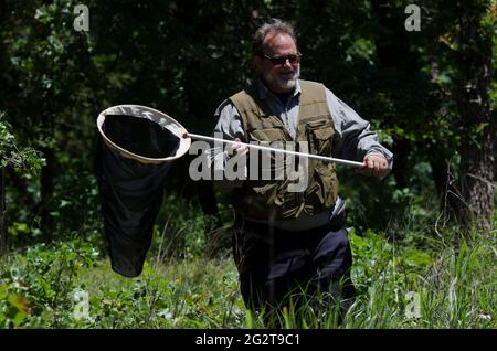 Man in his 60's searching for butterflies Stock Photo