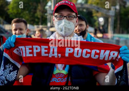 Moscow, Russia. 12th of June, 2021 A football fan wearing a respirator and gloves visits the Fan Zone where will be streaming the UEFA Euro 2020 Group B match between Belgium and Russia, near Luzhniki Stadium in Moscow, Russia. The inscription on the fan's scarf reads 'Forward, Russia'