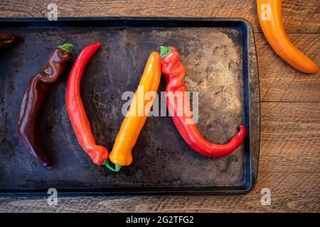 Colorul Poivron peppers being prepped on a wood table for roasting in the oven Stock Photo